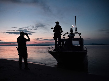 عنصران من خفر السواحلي اليوناني يراقبان الحدود اليونانية التركية في دلتا نهر إيفروس بالقرب من ألكساندروبولي، 8 يونيو 2021 - AFP