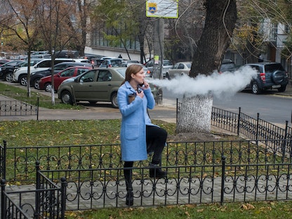 امرأة تدخن سجائر إلكترونية في أحد شوارع العاصمة الأوكرانية كييف - 2 نوفمبر 2018 - REUTERS