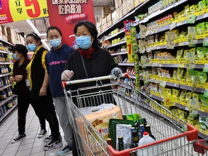 متسوقون يتبضّعون من متجر في بكين مرتدين كمامات للوقاية من فيروس كورونا - 3 نوفمبر 2021 - REUTERS