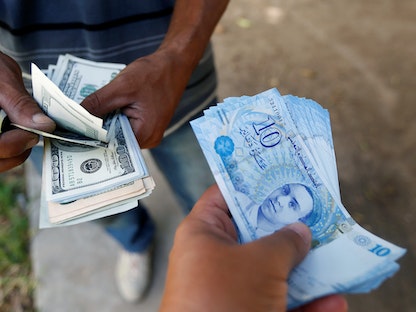 رجل يشتري دولارات في العاصمة تونس. 24 أغسطس 2017 - REUTERS