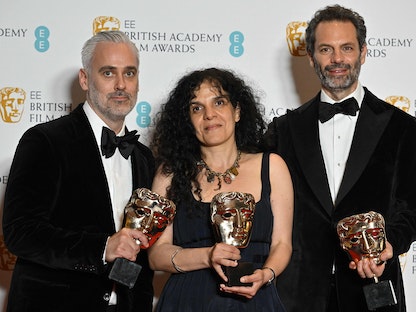 المنتجان البريطانيان إيان كانينج وتانيا سيجاتشيان والمنتج الأسترالي إميل شيرمان مع المخرجة النيوزيلندية جين كامبيون يستعرضون جوائزهم عن فيلم "قوة الكلب" بأكاديمية بافتا البريطانية في لندن- 13 مارس 2022 - AFP