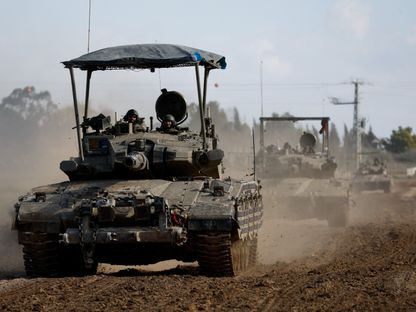 رتل من الآليات العسكرية الإسرائيلية على حدود غزة بالتزامن مع قصف مدفعي وغارات جوية مستمرة على القطاع. 24 يناير 2024 - Reuters