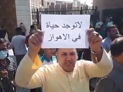 إيراني يرفع لافتة كتب عليها "لا توجد حياة في الأهواز" خلال احتجاجات في خوزستان - 10 يوليو 2021  - Twitter/@PADMAZorg