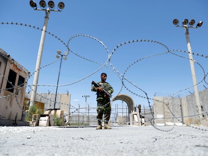 جندي أفغاني يحرس بوابة قاعدة "باغرام" الجوية الأميركية - 2 يوليو 2021 - REUTERS