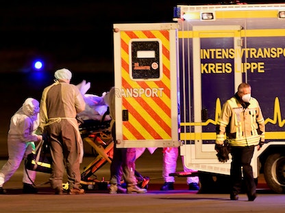 مسعفون ينقلون مريضاً مصاباً بكورونا في مدينة غريفين الألمانية- 26 نوفمبر 2021 - REUTERS
