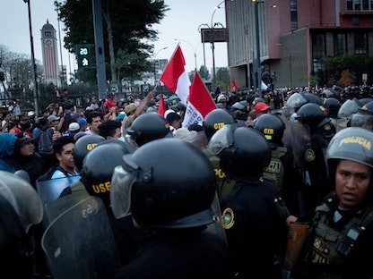 عناصر الشرطة أمام متظاهرين في ليما، عاصمة البيرو - 15 ديسمبر 2022 - Bloomberg