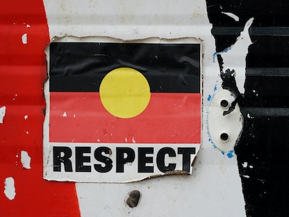 كلمة "الاحترام" على ملصق لعلم السكان الأصليين الأسترالي في العاصمة كانبرا - REUTERS