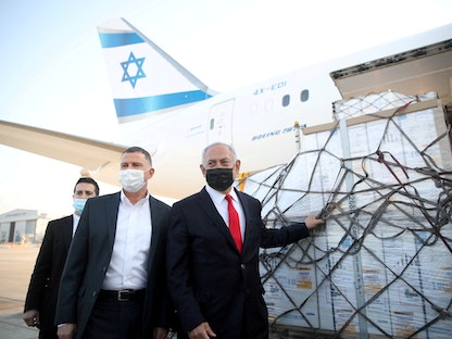 رئيس الوزراء الإسرائيلي السابق زعيم المعارضة بينيامين نتنياهو خلال استقبال شحنة لقاحات من شركة فايزر في مطار بن غوريون، إسرائيل، 10 يناير 2021 - REUTERS