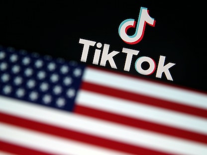شعار تطبيق "تيك توك" وفي الخلفية علم الولايات المتحدة - REUTERS