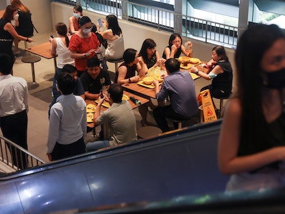 موظفون خلال استراحة الغداء في سنغافورة - 26 أبريل 2022 - REUTERS