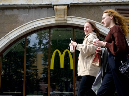 سيدتان تسيران أمام أحد فروع مطعم ماكدونالدز في العاصمة الروسية موسكو. 16 مايو 2022 - AFP