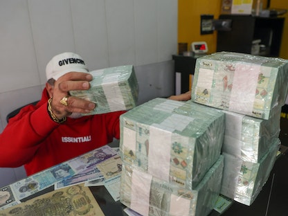صرّاف يعد أوراقاً نقدية بالليرة اللبنانية داخل متجر في بيروت. 19 يناير 2023 - REUTERS