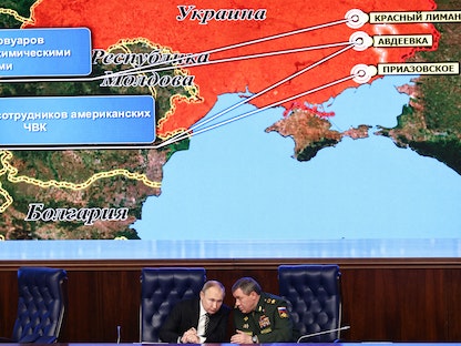 الرئيس الروسي فلاديمير بوتين يستمع إلى رئيس أركان القوات المسلحة فاليري جيراسيموف أمام شاشة ضخمة تظهر خريطة أوكرانيا خلال الاجتماع السنوي لمجلس وزارة الدفاع في موسكو - 21 ديسمبر 2021 - AFP