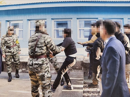 صورة غير مؤرخة وزّعتها وزارة التوحيد الكورية الجنوبية في 13 يوليو 2022، تُظهر رجلاً كورياً شمالياً متهماً بالقتل يقاوم تسليمه إلى مسؤولين كوريين شماليين عبر بلدة بانمونجوم الحدودية - AFP