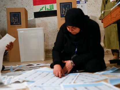 مسؤولة عراقية تعمل في مركز اقتراع خلال الانتخابات النيابية في بغداد، 10 أكتوبر 2021 - REUTERS