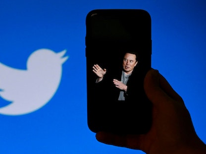 شاشة هاتف تعرض صورة إيلون ماسك مع شعار Twitter الموضح في الخلفية- 4 أكتوبر 2022 - AFP