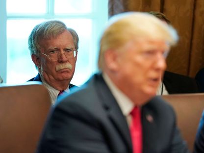 الرئيس دونالد ترمب وفي الخلفية مستشار الأمن القومي السابق جون بولتون بالبيت الأبيض - REUTERS
