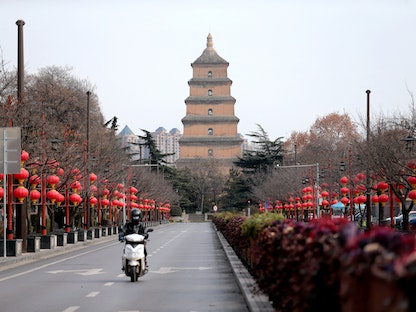 مواطن يسير في شارع خال بعد إجراءات الإغلاق للحد من انتشار مفيروس كورونا في شيان، مقاطعة شنشي، الصين - 26 ديسمبر 2021. - VIA REUTERS