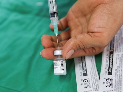 عامل في مجال الرعاية الصحية يقوم بتحضير جرعة من لقاح "فايزر" في كوستاريكا - 24 فبراير 2021 - REUTERS