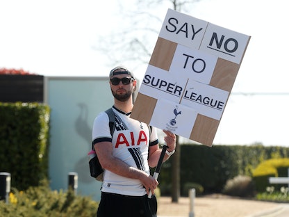 مشجع لفريق توتنهام الإنجليزي يحمل لافتة كتب عليها "لا للسوبر ليغ" - REUTERS