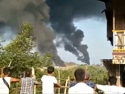 أشخاص ينظرون إلى أعمدة كثيفة من الدخان الأسود من مقاطعة ساغاينج، ميانمار، 22 مايو 2021 - REUTERS