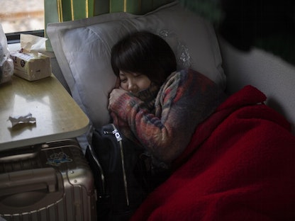 راكبة تستلقي في سرير نوم داخل قطار في العاصمة الصينية بكين - 29 يناير 2019 - AFP