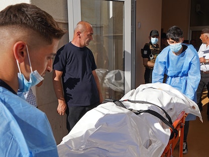 مسعفون ينقلون جثمان أحد ضحايا القصف التركي على مدينة زاخو شمال إقليم كردستان العراق- 20 يوليو 2022 - AFP