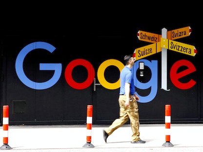 شخص يمر بجوار شعار جوجل في مدينة زيورخ السويسرية. 1 يوليو 2020 - REUTERS