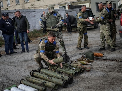 قوات أوكرانية تجمع قذائف وألغاماً وأسلحة بعد سيطرتها على قرية أوديفي خاركوف - أوكرانيا - 12 سبتمبر 2022 - REUTERS