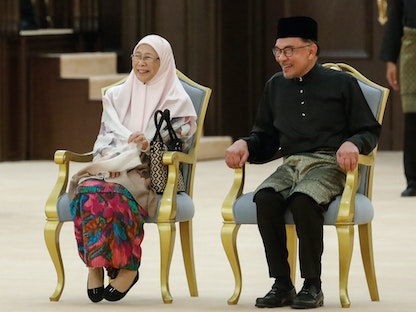 رئيس الوزراء الماليزي الجديد أنور إيراهيم وزوجته وان عزيزة خلال مراسم أداء الحكومة الجديد اليمين في كوالالمبور. 3 ديسمبر 2022 - AFP