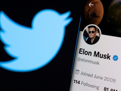 حساب الملياردير إيلون ماسك أمام شعار تويتر  - REUTERS