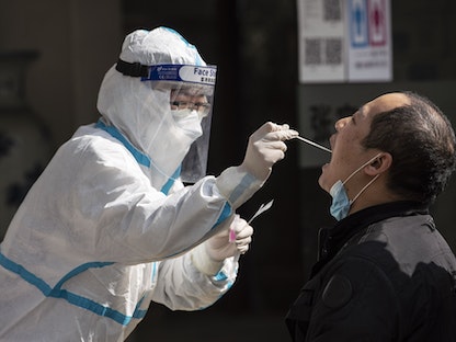 عاملة طبية تجري فحصاً للكشف عن فيروس كورونا في مدينة شنغهاي الصينية - 6 فبراير 2021 - Bloomberg