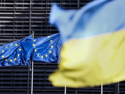 العلم الأوكراني أمام علم الاتحاد الأوروبي خارج مقر المجلس الأوروبي في بروكسل. 16 مايو 2022  - AFP