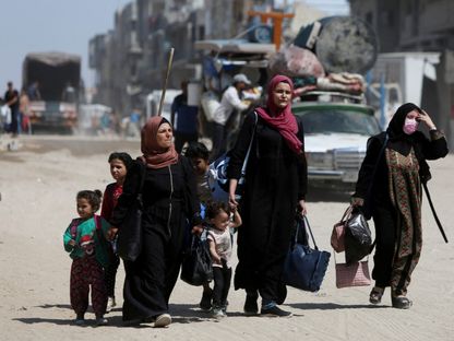 فلسطينيون يحملون أمتعتهم أثناء فرارهم من منازلهم بعد أن أصدر الجيش الإسرائيلي أوامر إخلاء من مركز خان يونس جنوب قطاع غزة. 3 يونيو 2025 - REUTERS