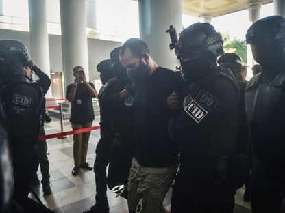 الإسرائيلي المتهم شالوم أفيتان (وسط) ترافقه الشرطة الماليزية عند وصوله إلى المحكمة في كوالالمبور. 12 أبريل 2024 - AFP