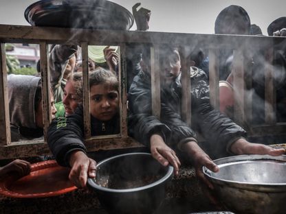 أطفال فلسطينيون نازحون خلال الانتظار للحصول على الغذاء بمدرسة حكومية في رفح، جنوب قطاع غزة. 19 فبراير 2024 - AFP