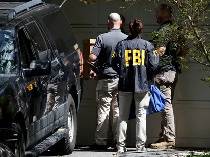 عملاء مكتب التحقيقات الفيدرالي FBI بعد تفتيش منزل مستشار الأمن القومي الأميركي السابق في مدينة بيثيسدا بولاية ماريلاند. 22 أغسطس 2025 - REUTERS