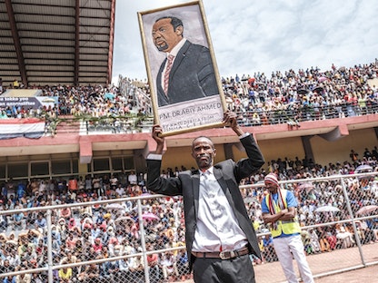 رجل يحمل صورة لرئيس الوزراء الإثيوبي أبي أحمد في ملعب بمدينة جيما، 16 يونيو 2021 - AFP