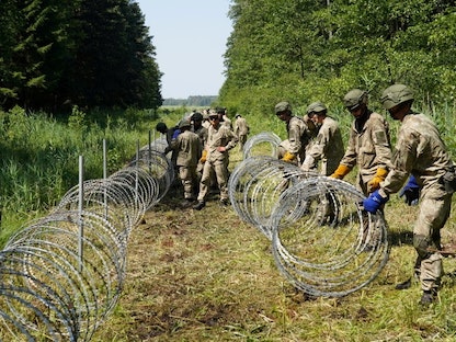 جنود من الجيش الليتواني يقومون بتثبيت أسلاك شائكة على طول الحدود مع بيلاروسيا في دروسكينينكاي - 9 يوليو 2021 - REUTERS