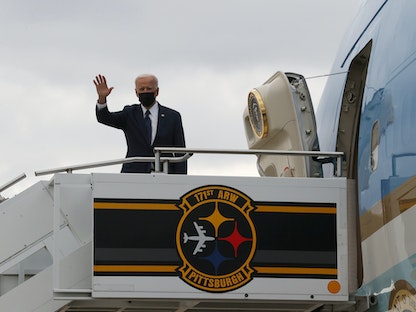 الرئيس الأميركي جو بايدن يلوح من أعلى سلم طائرة الرئاسة "إير فورس وان" - REUTERS