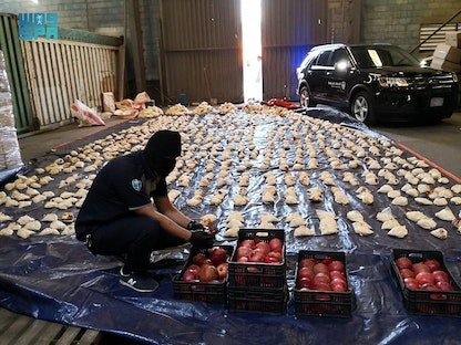 جانب من عملية ضبط السلطات السعودية ملايين الحبوب المخدرة مخفية داخل شحنتين من فاكهة الرمان قادمتين من لبنان - واس