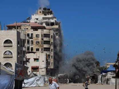 فلسطينيون يركضون بينما يتصاعد الدخان من مبنى سكني قصفه الجيش الإسرائيلي في مدينة غزة. 14 سبتمبر 2025 - Reuters