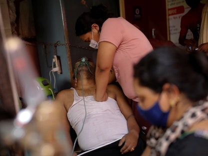 شابة هندية تضغط على صدر والدها لإنعاشه، بعد فقدانه الوعي بسبب إصابته بكورونا - غازي أباد - الهند - 30 أبريل 2021 - REUTERS