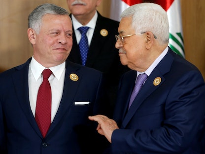  العاهل الأردني الملك عبد الله الثاني يتحدث مع الرئيس الفلسطيني محمود عباس قبيل القمة العربية الثلاثين في تونس، 31 مارس 2019 - REUTERS