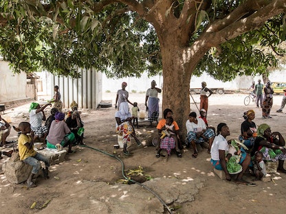 نازحون يجلسون تحت شجرة بعد وصولهم قرية بوجينا، جامبيا - 15 مارس 2022. - AFP