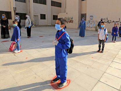 تلاميذ يقفون في صف وهم يرتدون الأقنعة بعد استئناف الدراسة في العاصمة الأردنية عمان - 1 سبتمبر 2020 - AFP