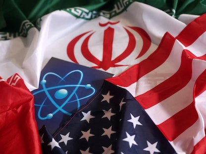 صورة تعبيرية تجمع بين علمي الولايات المتحدة وإيران والشعار النووي. - REUTERS