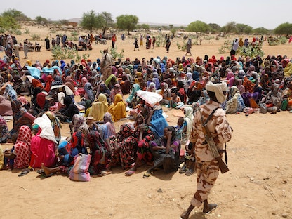 لاجئون سودانيون ينتظرون تلقي دعماً من برنامج الغذاء العالمي بالقرب من الحدود بين السودان وتشاد في كفرون، تشاد. 9 مايو 2023 - REUTERS