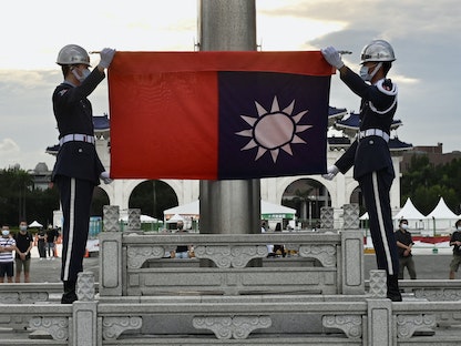 حراس الشرف يلفون علم تايوان خلال حفل إنزال العلم في قاعة شيانج كاي شيك التذكارية في تايبيه، تايوان في 4 يونيو 2022 - AFP