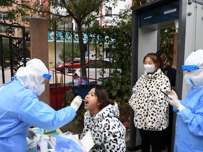 عامل طبي يجمع مسحة من أحد السكان في موقع لاختبار الحمض النووي بعد ظهور حالات جديدة من فيروس كورونا في لانتشو ـ الصين في 20 أكتوبر 2021. - VIA REUTERS